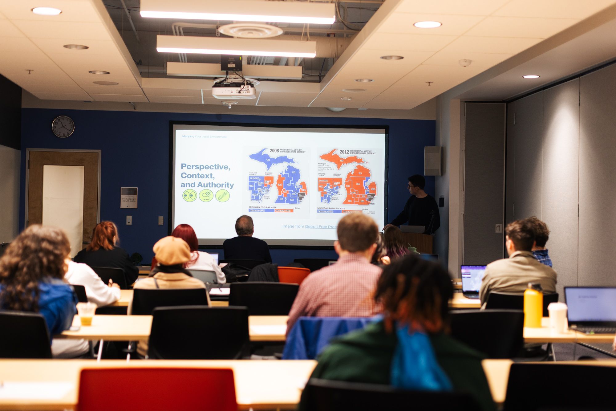 Workshop participants in a classroom setting examining gerrymandering maps